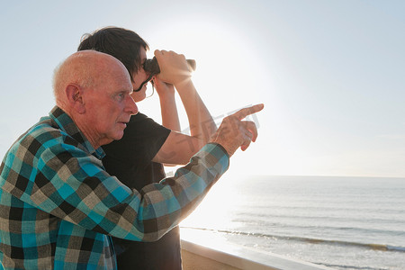 老人和孙子眺望大海