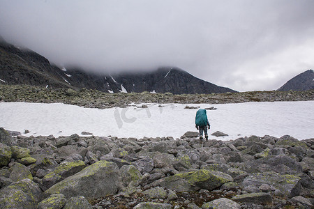 年轻的男性徒步旅行者向外望着结冰的湖乌拉尔山脉俄罗斯