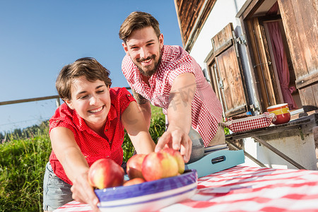 奥地利蒂罗尔小屋外拿着苹果的年轻夫妇