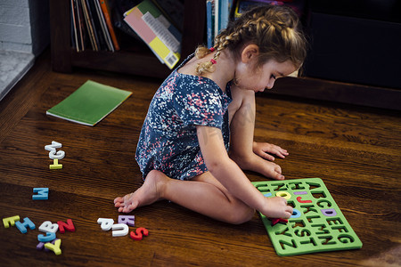 定位孩子摄影照片_女幼儿坐在地板上玩字母益智玩具