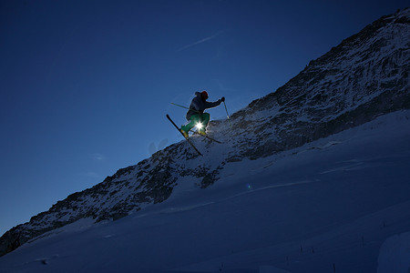 保暖衣物摄影照片_男子滑雪者在晴朗的蓝天下跳跃