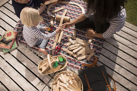 玩具火车轨道摄影照片_母子俩玩木制玩具铁轨高角