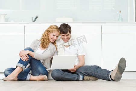 家居移门摄影照片_一对夫妇正在调查笔记本电脑