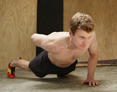 中年男性在健身房做单臂俯卧撑
