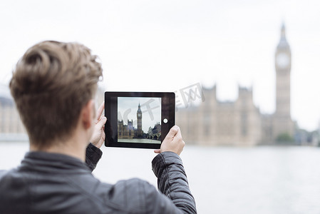 在数字平板电脑上拍摄大本钟的年轻人的背影英国伦敦