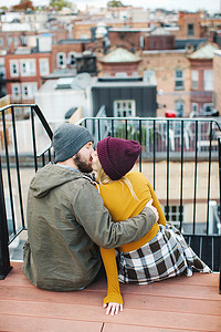 追逐摄影照片_年轻夫妇在城市屋顶露台接吻
