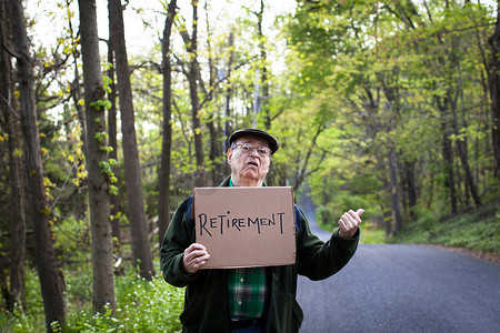 社会人类摄影照片_在森林里举着牌子的老年人肖像