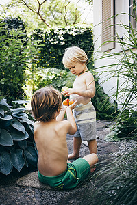 在花园里的小路上吃橘子的男孩布卢登茨奥地利