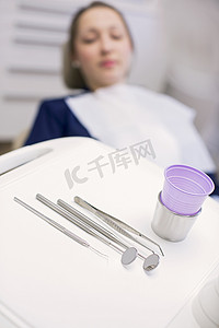 坐在牙医椅上等待牙科检查的年轻女子看着牙科设备