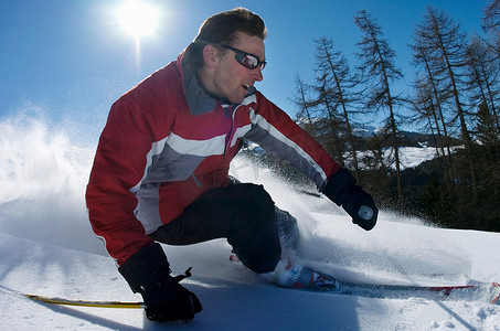 民族雕刻摄影照片_滑雪者在粉雪中雕刻