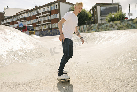 年轻男子滑板运动员在滑板公园滑板