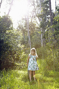 在森林里靠着树站着的女孩