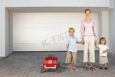 母亲和孩子们站在车库外