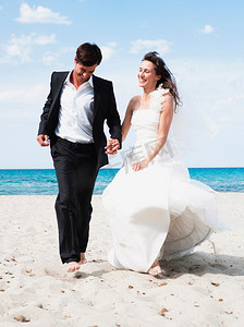 新娘和新郎沿着海滩奔跑