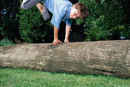男孩跳过一根圆木