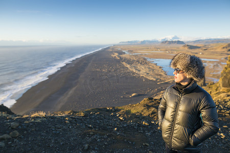 追逐摄影照片_冰岛海滩附近欣赏风景的成熟女子