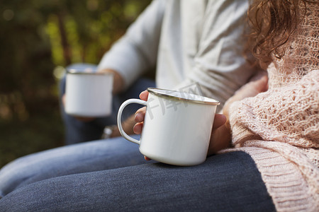 一对情侣坐在花园里端着咖啡杯的剪影