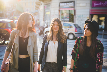 三名年轻女子在城市街道上漫步