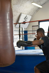 青少年搏击摄影照片_拳击手在健身房使用拳击袋