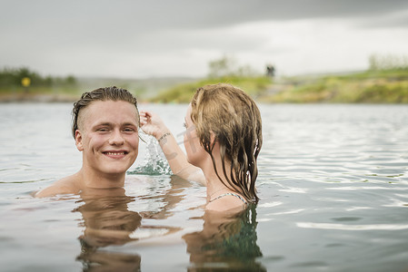 冰岛弗夫迪尔年轻夫妇在秘密泻湖温泉嬉水