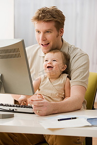 父母与孩子沟通摄影照片_使用电脑的父亲和女儿