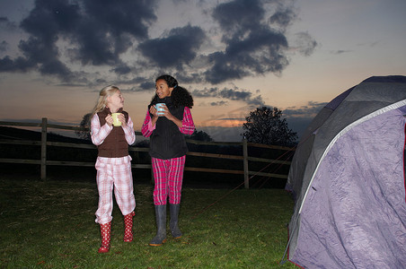 黑帐篷摄影照片_黄昏时分女孩们走向帐篷