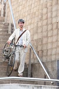 楼梯防护摄影照片_骑着自行车在台阶上的年轻人