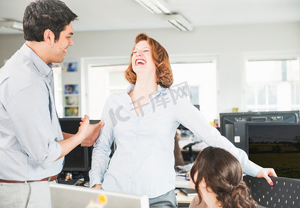 中年女性大笑摄影照片_同事在办公室里大笑