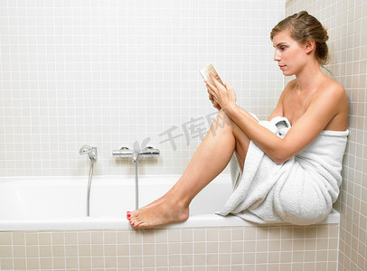 一名妇女在卫生间里看书