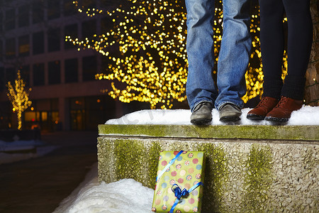 站在城市积雪覆盖的城墙上的年轻夫妇的腿