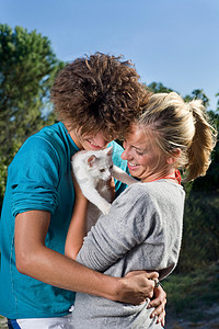 年轻夫妇与小猫集体拥抱
