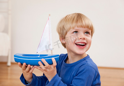感恩毛笔字摄影照片_带着玩具船的男孩