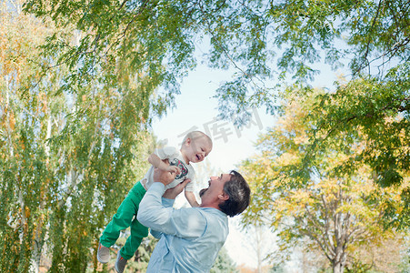 爷爷抱孙子摄影照片_爷爷在公园里抱孙子