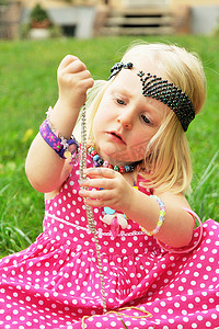 短发少女摄影照片_一个在后院玩珠宝的女孩