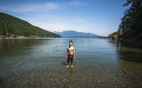 回门典礼摄影照片_加拿大不列颠哥伦比亚省博文岛一名男子在海里把湿头发甩回