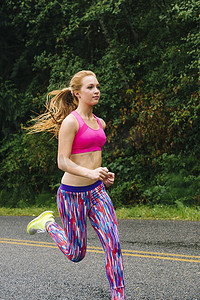 十几岁的女跑步者在乡村公路上跑步