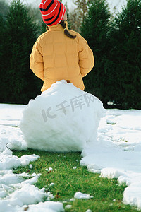 雪球摄影照片_坐在大雪球上的女孩