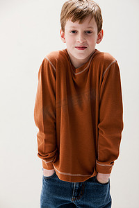 男孩穿着棕色毛衣双手插在口袋里摄影棚拍摄