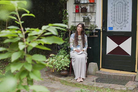 坐在小木屋门廊外的年轻女子