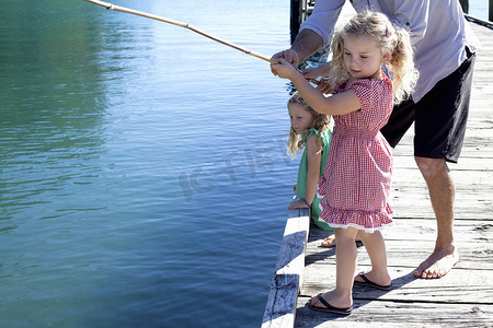 成熟的男人和女儿在新西兰的皮尔钓鱼