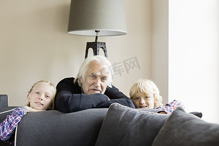倚靠摄影照片_倚靠在沙发上的祖父和孙子的肖像