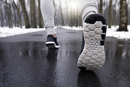 年轻人在雪林中慢跑低矮的路段后视线