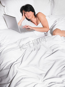 躺在床上玩电脑的女人