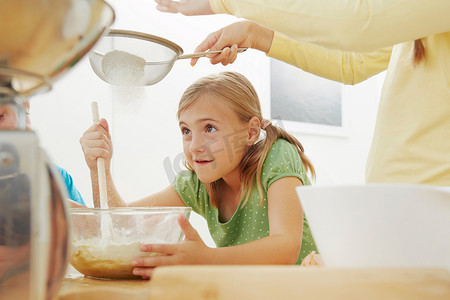 孩子们烘焙把面粉筛进搅拌碗里