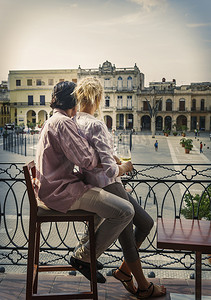 古巴哈瓦那广场一对浪漫的年轻夫妇从餐厅阳台上向外张望