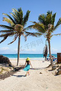 行走的女人摄影照片_走在热带海滩上的女人