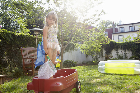 蝴蝶和人摄影照片_穿着蝴蝶服装的女孩站在玩具马车里