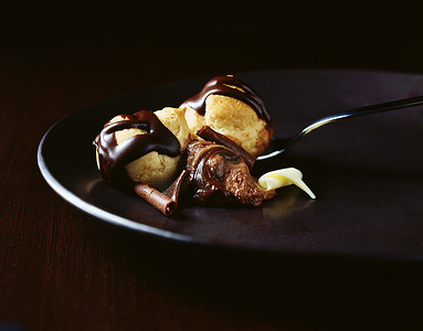老鼠图案摄影照片_巧克力老鼠盘上用勺子包着巧克力的普洛佩洛尔