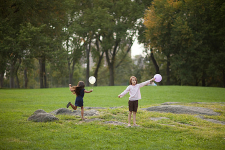 动物园派对摄影照片_女孩们在生日聚会上举着气球