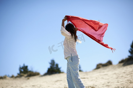穿红围巾的女子在海滩上畅游